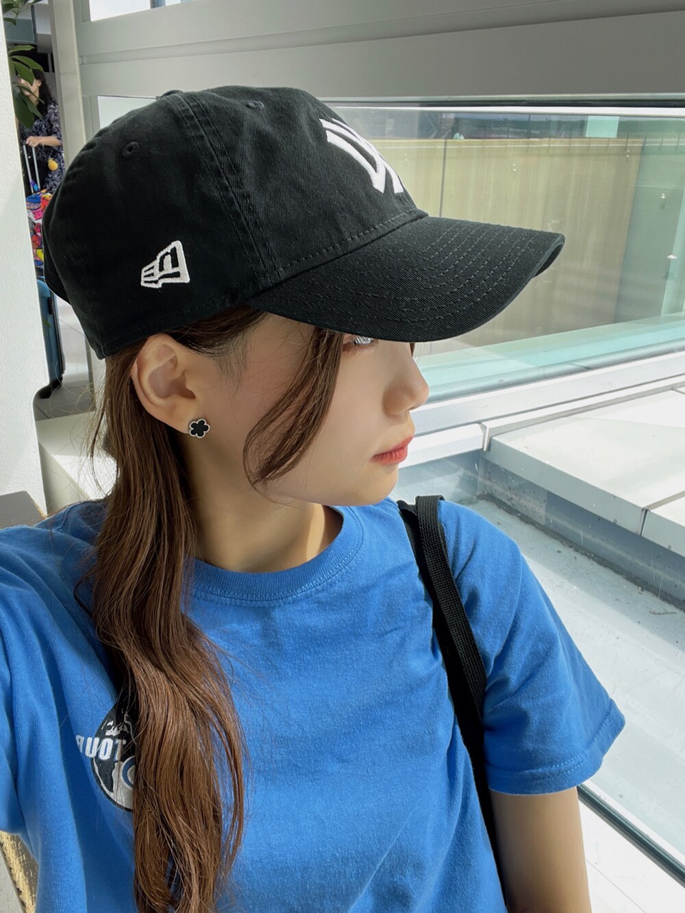 ブラック系のカーゴパンツ、ブラック系のスニーカー、ブラック系のショルダーバッグを着用したレディースの夏コーディネートの2枚目の写真