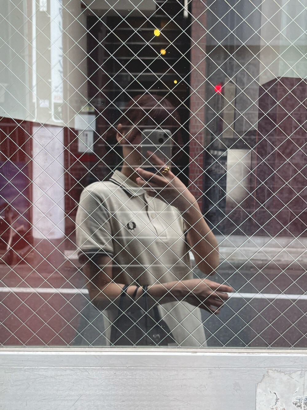 ブラック系のスニーカー、ベージュ系のワンピース、ブラック系のショルダーバッグを着用したレディースの夏コーディネートの2枚目の写真