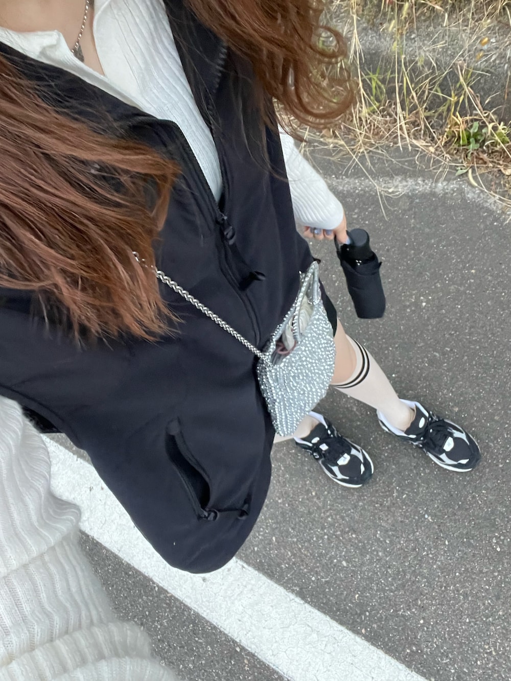 ブラック系のその他アウター、シルバー系のショルダーバッグ、ブラック系のスカートを着用したレディースの冬コーディネートの2枚目の写真