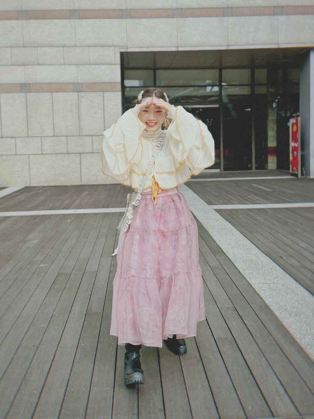 ホワイト系のニット/セーター、シルバー系のショルダーバッグ、ピンク系のスカートを着用したレディースの春コーディネートの2枚目の写真