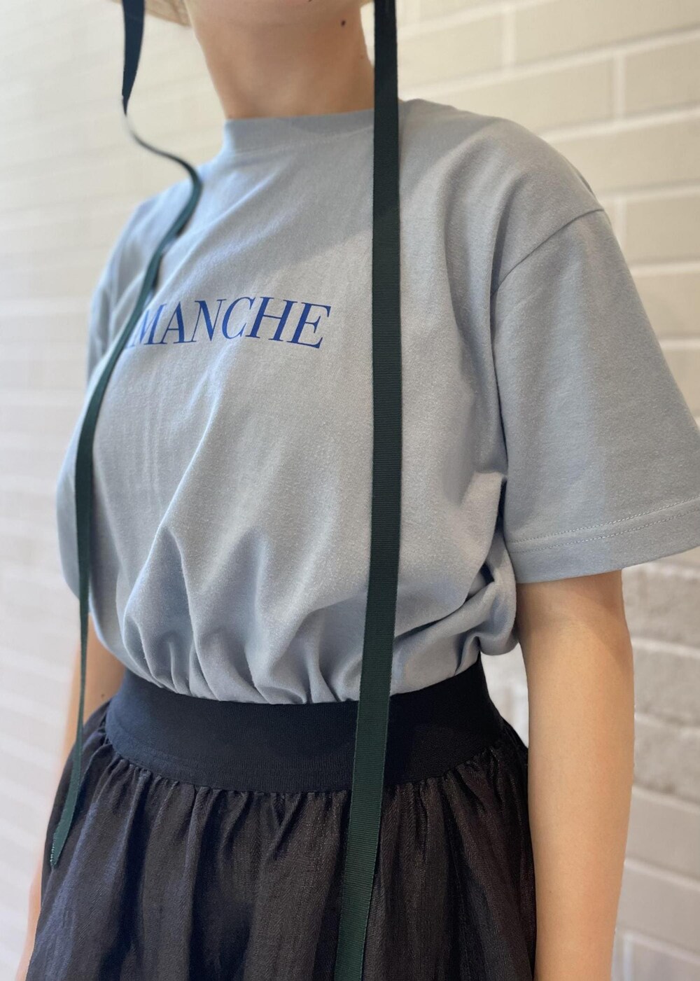 ベージュ系のサンダル、ブルー系のTシャツ/カットソー、ブラック系のスカートを着用したレディースの夏コーディネートの5枚目の写真