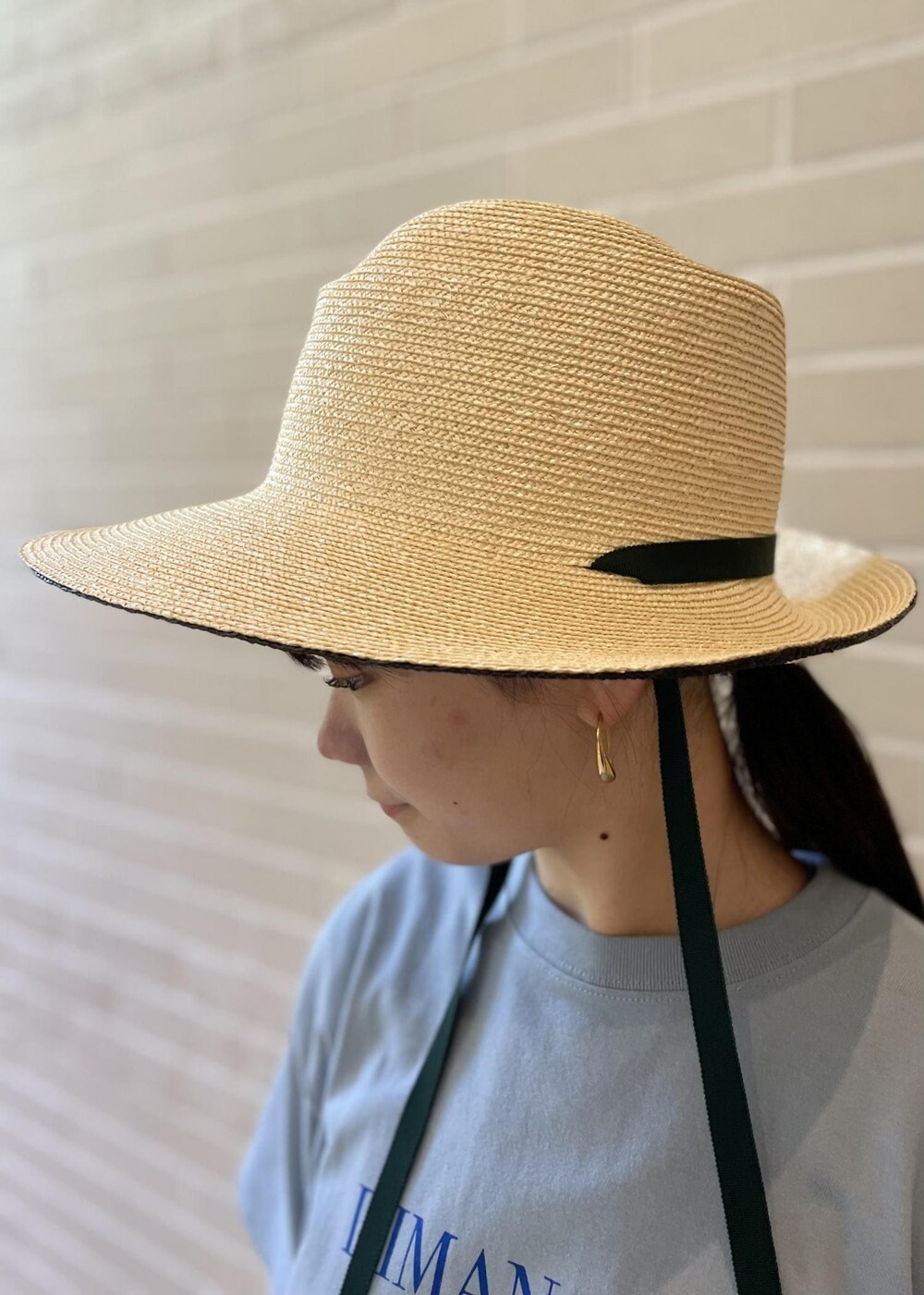 ベージュ系のサンダル、ブルー系のTシャツ/カットソー、ブラック系のスカートを着用したレディースの夏コーディネートの7枚目の写真