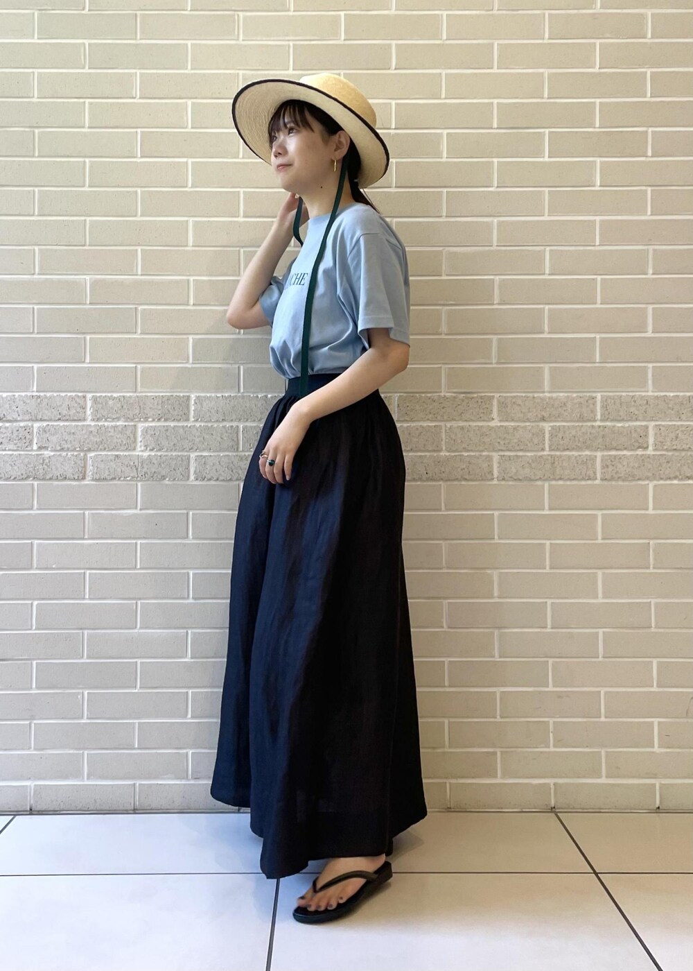 ベージュ系のサンダル、ブルー系のTシャツ/カットソー、ブラック系のスカートを着用したレディースの夏コーディネートの4枚目の写真