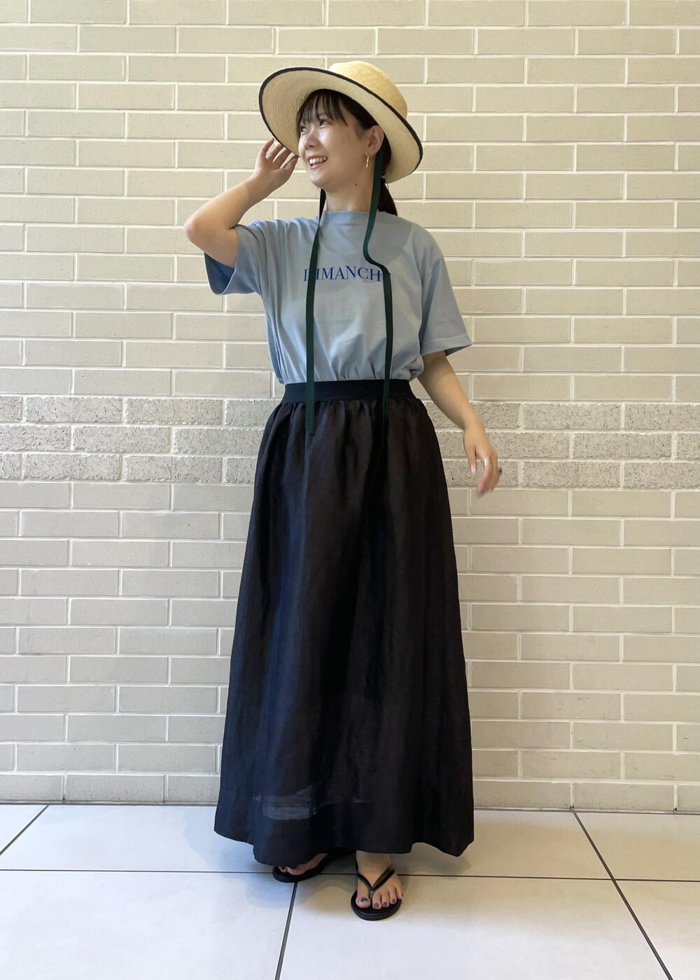 ベージュ系のサンダル、ブルー系のTシャツ/カットソー、ブラック系のスカートを着用したレディースの夏コーディネートの3枚目の写真