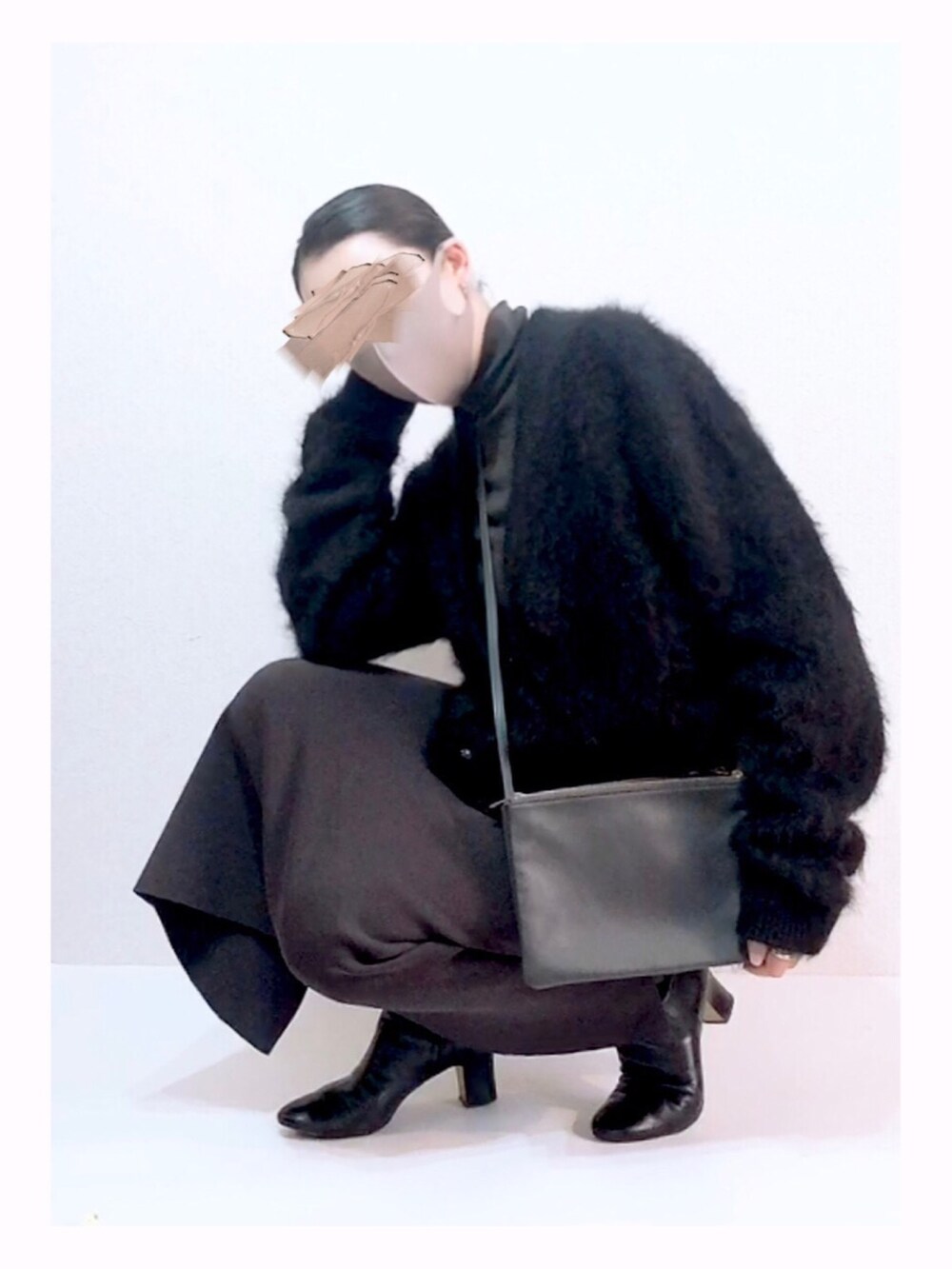 グレー系のスカート、ブラック系のブーツ、グレー系のショルダーバッグを着用したレディースの秋コーディネートの4枚目の写真