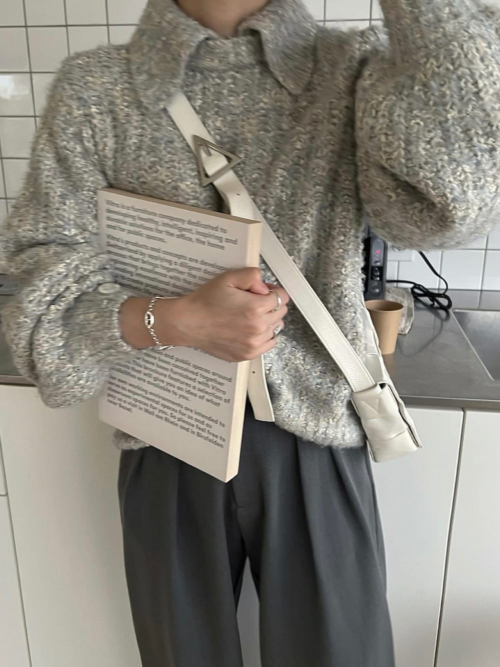 ブルー系のニット/セーター、ホワイト系のバッグを着用したレディースの秋コーディネートの3枚目の写真