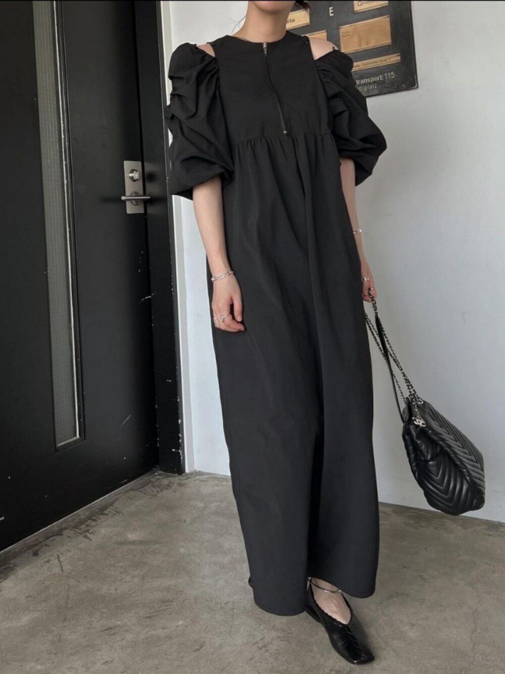 ブラック系のワンピースを着用したレディースの春コーディネートの2枚目の写真