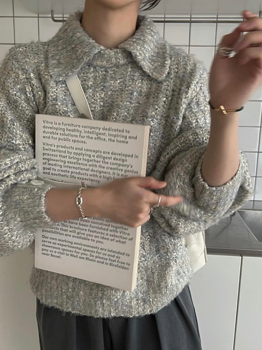 ブルー系のニット/セーター、ホワイト系のバッグを着用したレディースの秋コーディネートの5枚目の写真