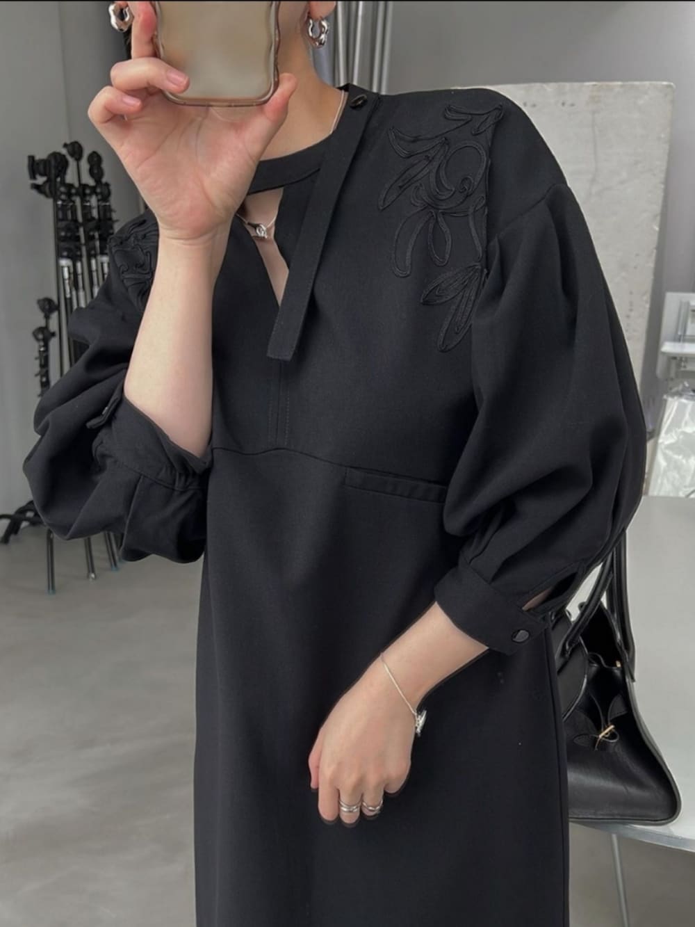 ブラック系のワンピース、ブラック系のハンドバッグを着用したレディースの夏コーディネートの3枚目の写真