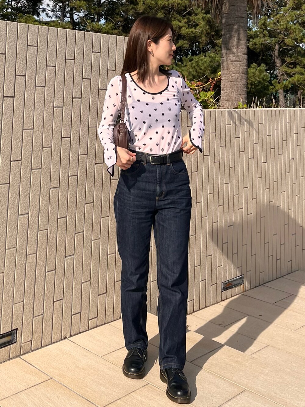 ブルー系のデニムパンツ、ブラック系のシューズ、ホワイト系のTシャツ/カットソーを着用したレディースの秋コーディネートの3枚目の写真