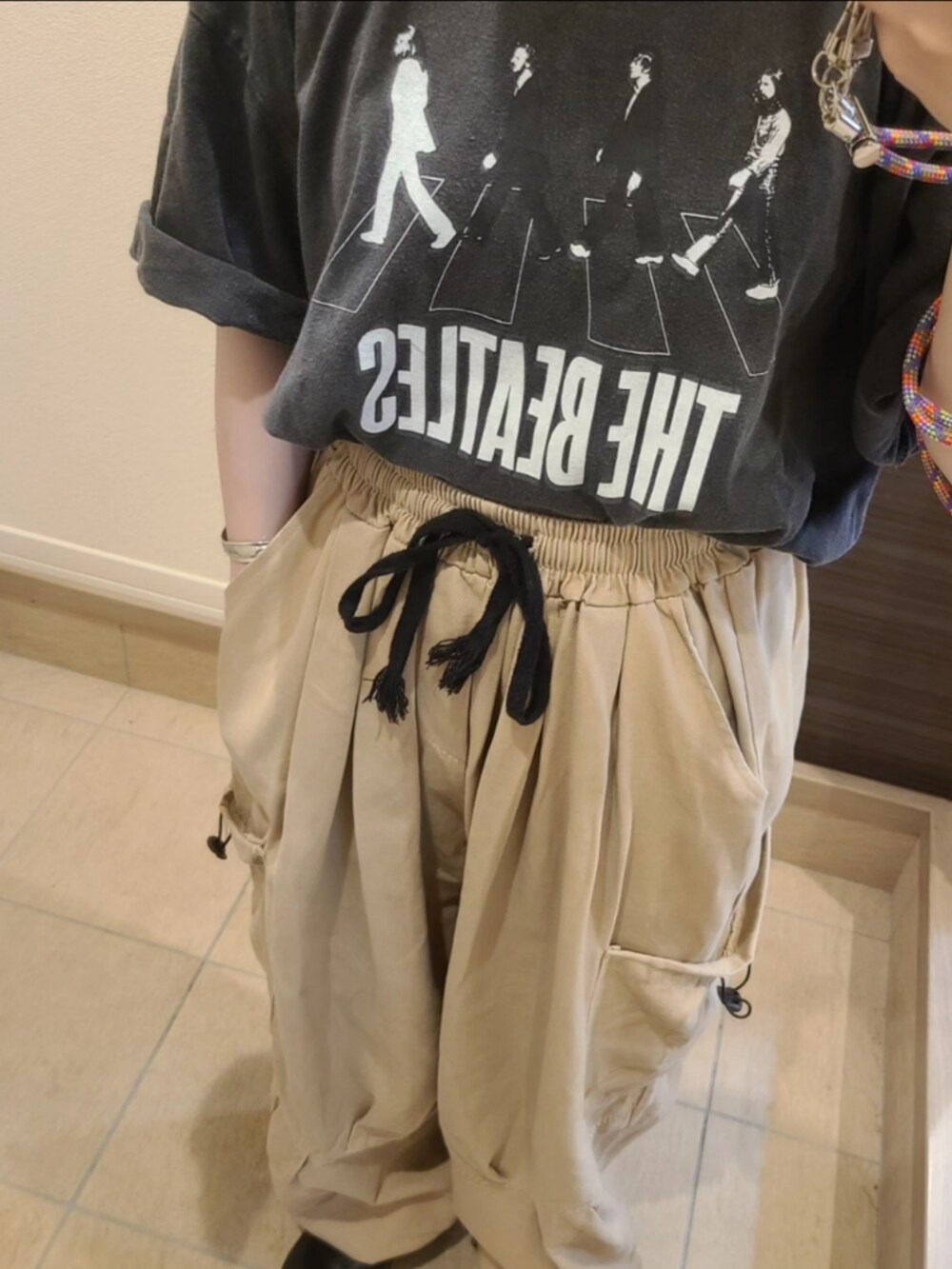 ブラック系のTシャツ/カットソー、ベージュ系のカーゴパンツを着用したレディースの夏コーディネートの2枚目の写真