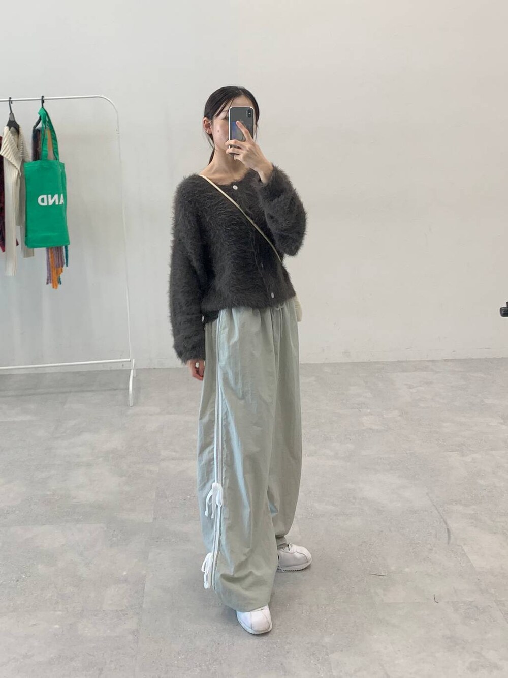 グレー系のその他パンツ、グレー系のカーディガン/ボレロ、ホワイト系のショルダーバッグを着用したレディースの秋コーディネートの2枚目の写真