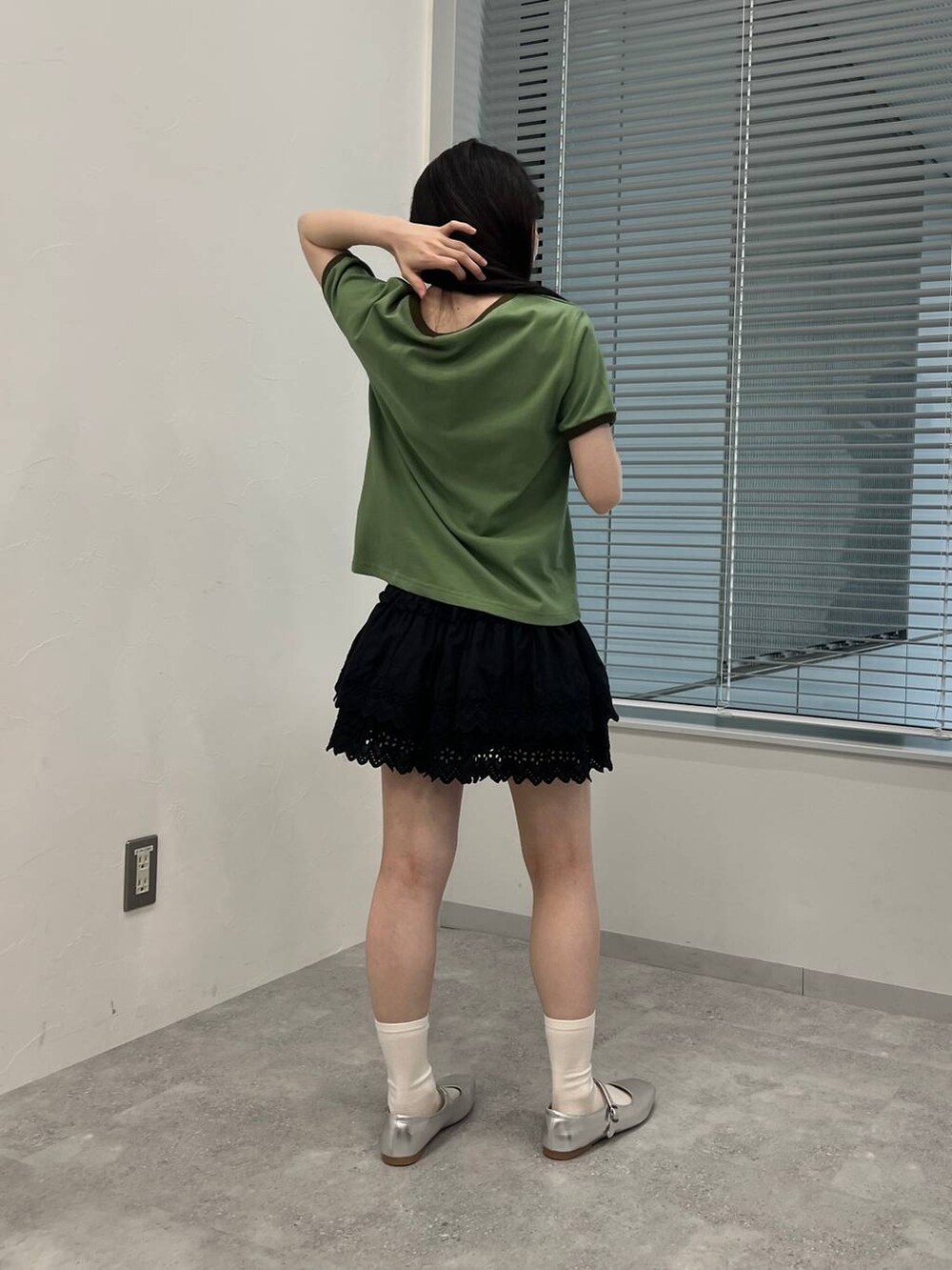 ブラック系のスカート、グリーン系のTシャツ/カットソーを着用したレディースの夏コーディネートの2枚目の写真