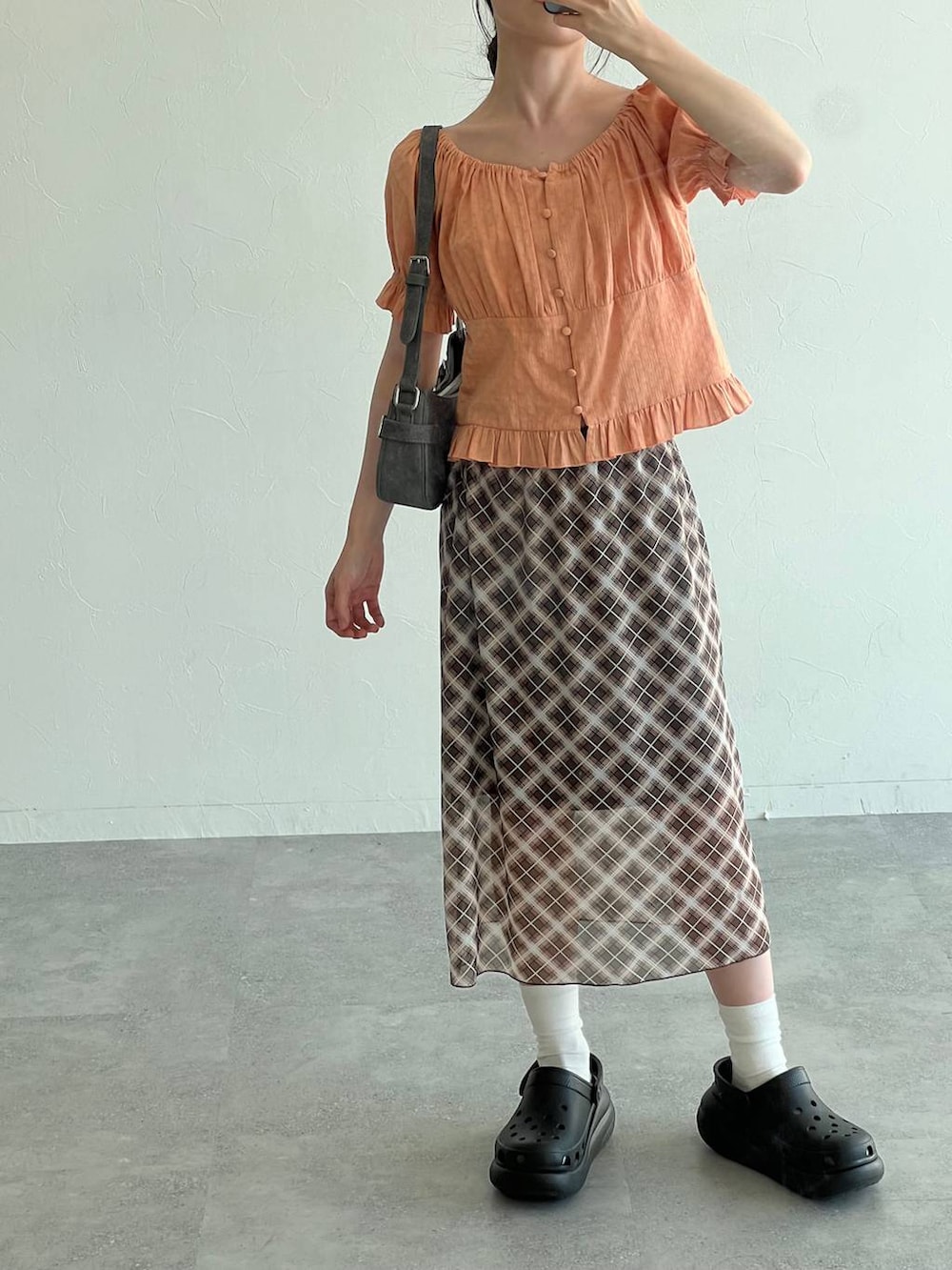 ブラック系のサンダル、オレンジ系のシャツ/ブラウス、ブラック系のトートバッグを着用したレディースの夏コーディネートの4枚目の写真