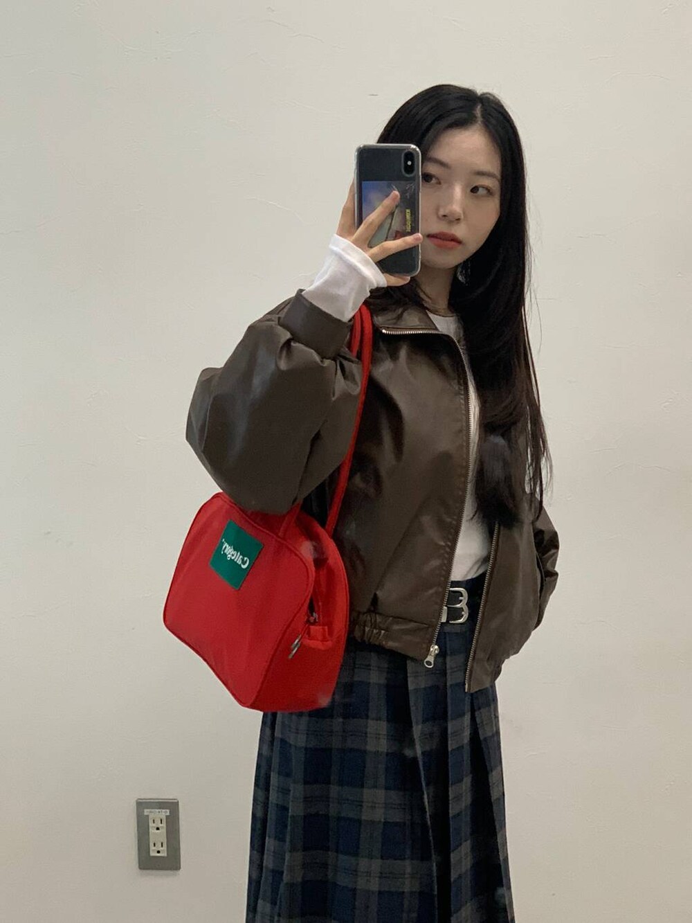 ブラック系のショルダーバッグ、ブラウン系のブルゾン、グレー系のスカートを着用したレディースの秋コーディネートの9枚目の写真