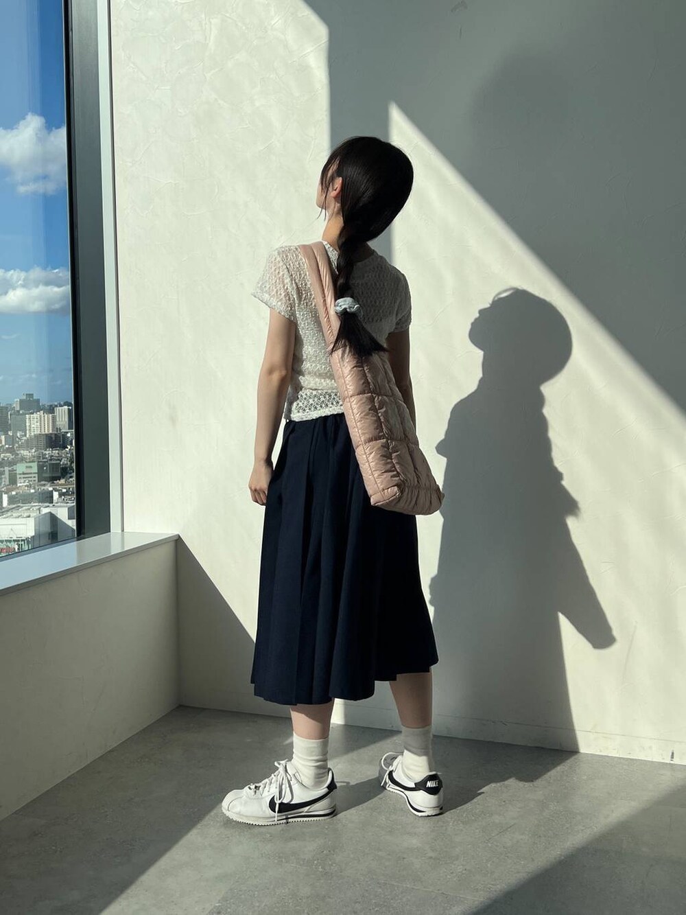 ブルー系のスカート、ホワイト系のTシャツ/カットソー、ピンク系のショルダーバッグを着用したレディースの夏コーディネートの3枚目の写真