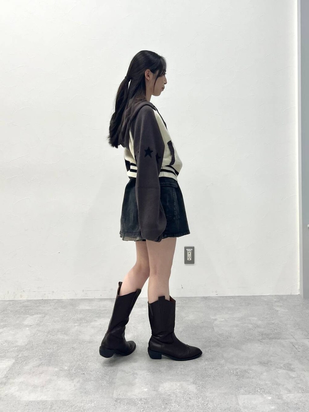 ブラウン系のスカート、ブラック系のデニムパンツを着用したレディースの春コーディネートの5枚目の写真