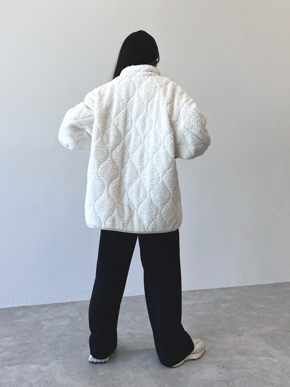 ブラック系のスラックス、ホワイト系のスニーカー、その他のブルゾンを着用したレディースの冬コーディネートの3枚目の写真