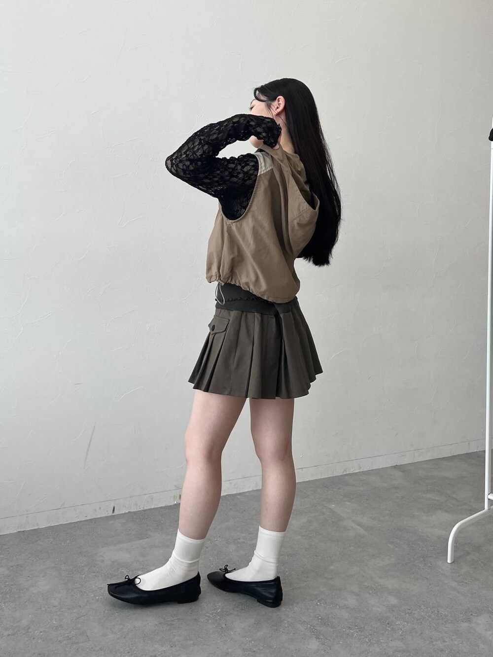 ベージュ系のベスト、ブラック系のTシャツ/カットソーを着用したレディースの春コーディネートの3枚目の写真