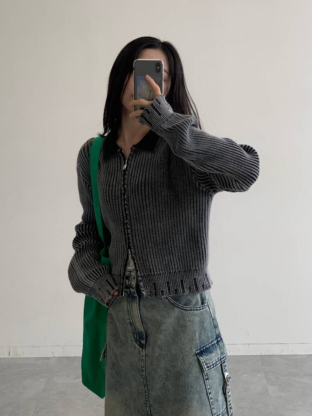 ブルー系のデニムスカート、グリーン系のトートバッグ、ブラック系のニット/セーターを着用したレディースの秋コーディネートの4枚目の写真