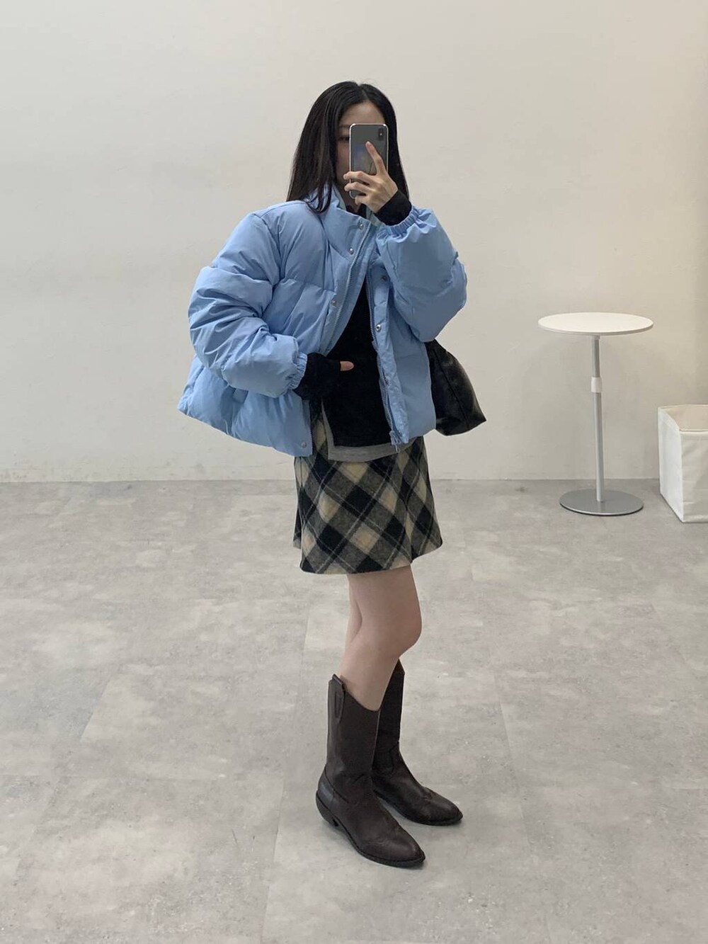 ブラック系のスカート、ブラック系のハンドバッグ、ブラック系のTシャツ/カットソーを着用したレディースの冬コーディネートの4枚目の写真