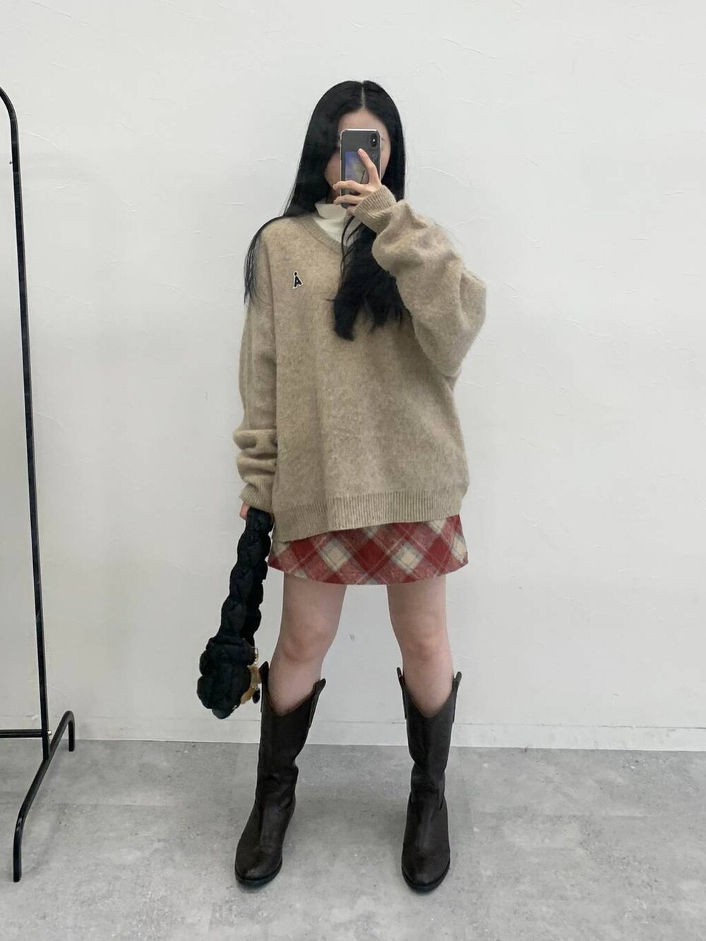 ブラック系のショルダーバッグ、レッド系のスカート、ベージュ系のTシャツ/カットソーを着用したレディースの冬コーディネートの2枚目の写真