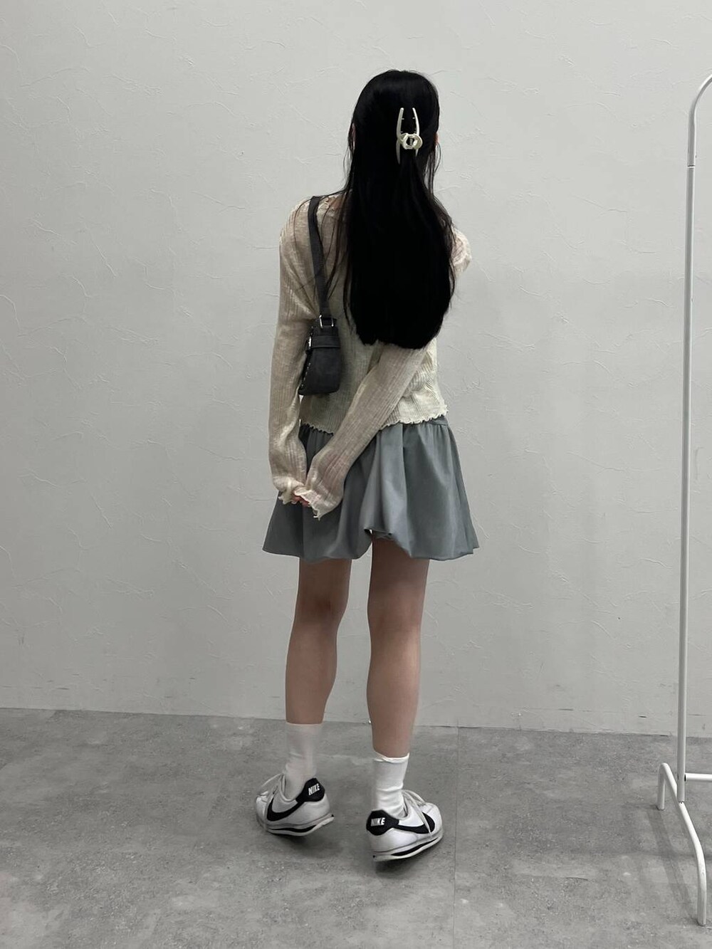 グレー系のスカート、ブラック系のトートバッグ、ベージュ系のカーディガン/ボレロを着用したレディースの夏コーディネートの6枚目の写真