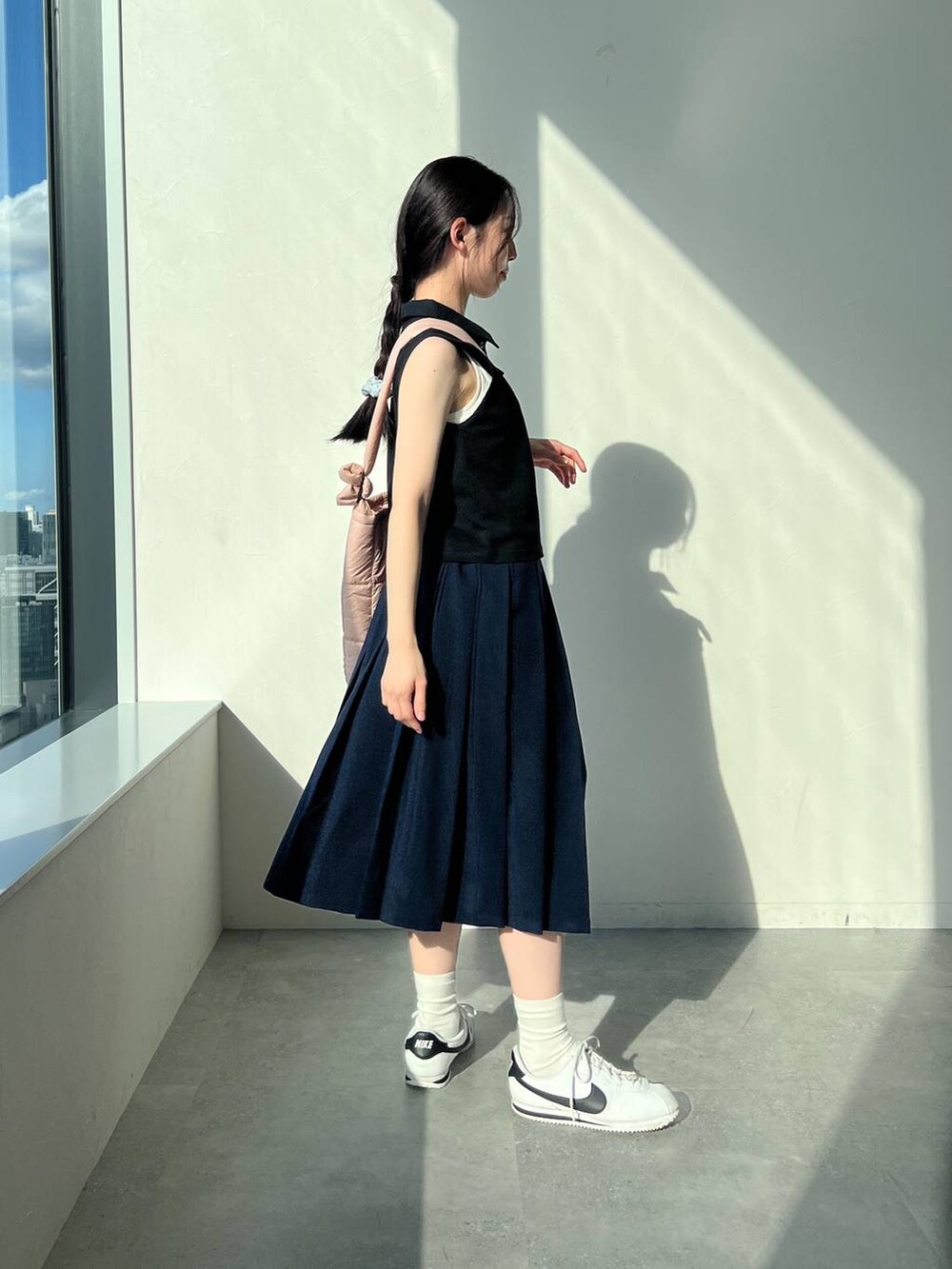 ブルー系のスカート、ピンク系のショルダーバッグ、ブラック系のタンクトップを着用したレディースの夏コーディネートの4枚目の写真