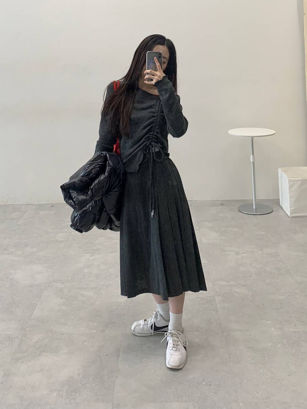 ブラック系のダウンジャケット/コート、グレー系のスカート、グレー系のTシャツ/カットソーを着用したレディースの冬コーディネートの3枚目の写真