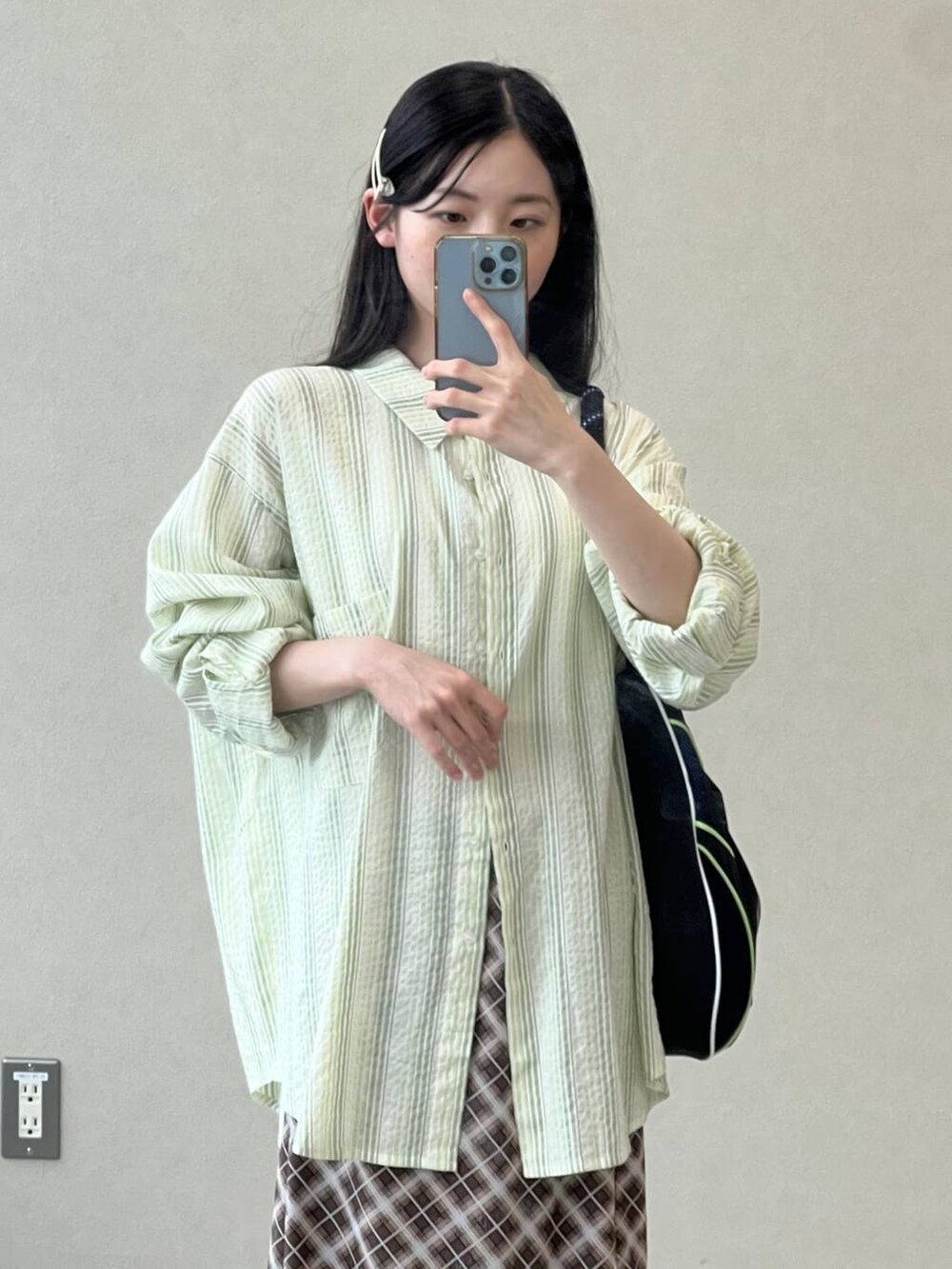 ブラウン系のスカート、グリーン系のシャツ/ブラウスを着用したレディースの夏コーディネートの3枚目の写真