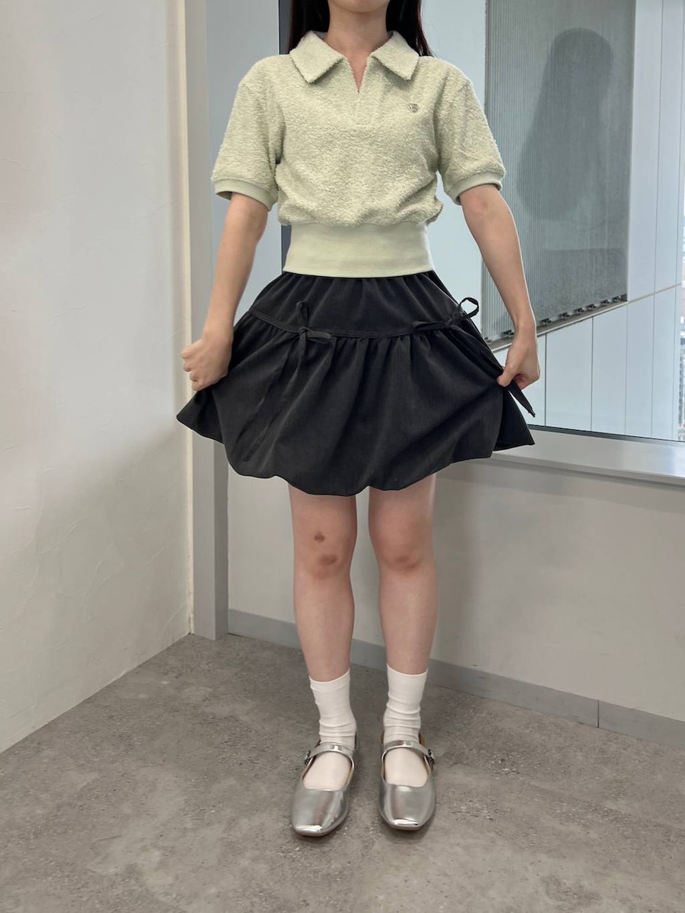 グレー系のスカート、グリーン系のTシャツ/カットソーを着用したレディースの夏コーディネートの2枚目の写真