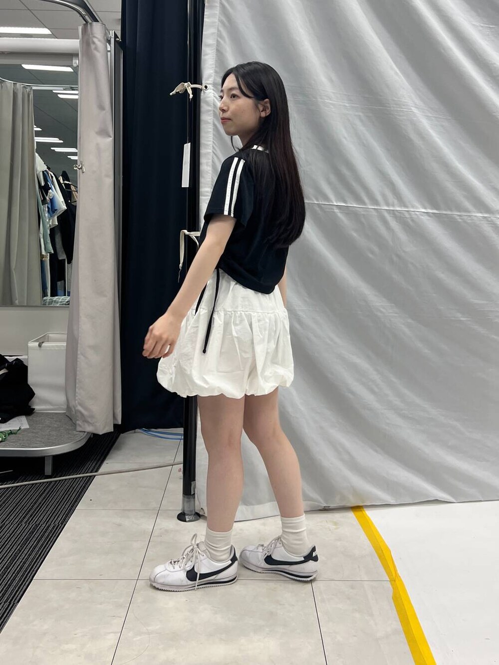 ホワイト系のスカート、ブラック系のTシャツ/カットソーを着用したレディースの夏コーディネートの2枚目の写真