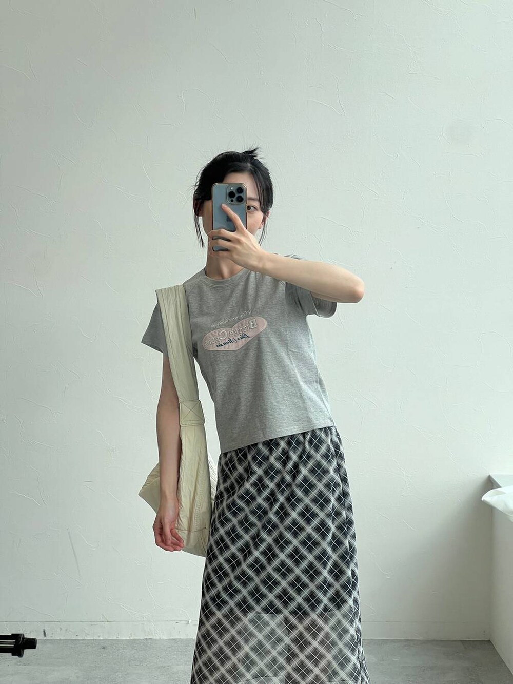 グレー系のTシャツ/カットソー、グレー系のスカート、ベージュ系のショルダーバッグを着用したレディースの夏コーディネートの4枚目の写真