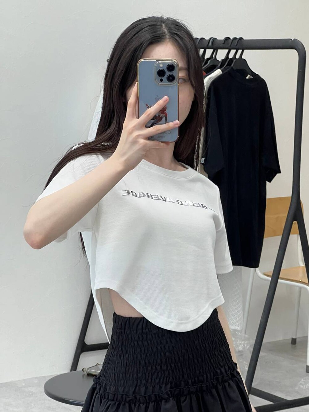 ブラック系のスカート、ホワイト系のTシャツ/カットソーを着用したレディースの春コーディネートの5枚目の写真