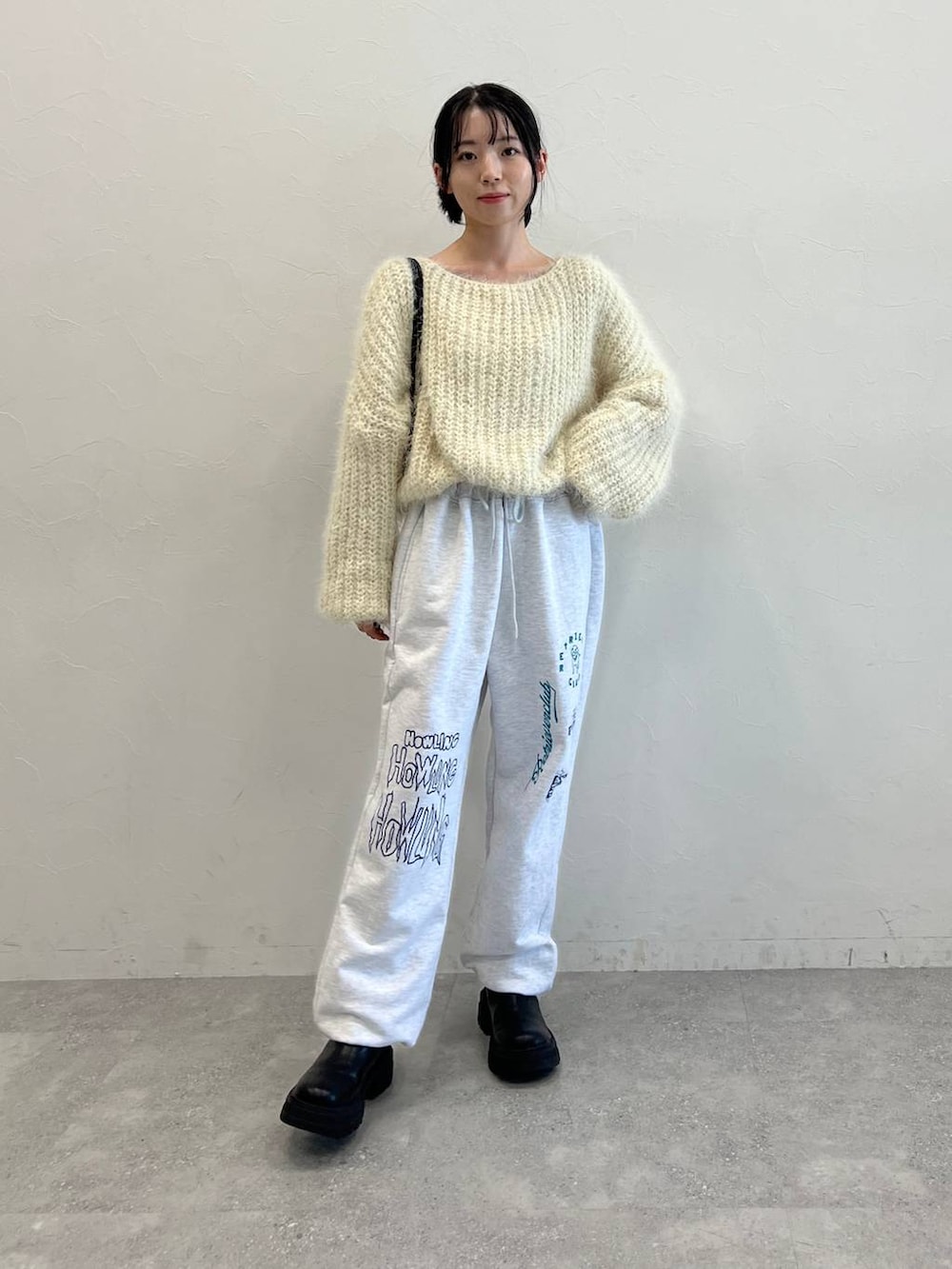 ブラック系のブーツ、ブラック系のショルダーバッグ、ベージュ系のニット/セーターを着用したレディースの冬コーディネートの3枚目の写真