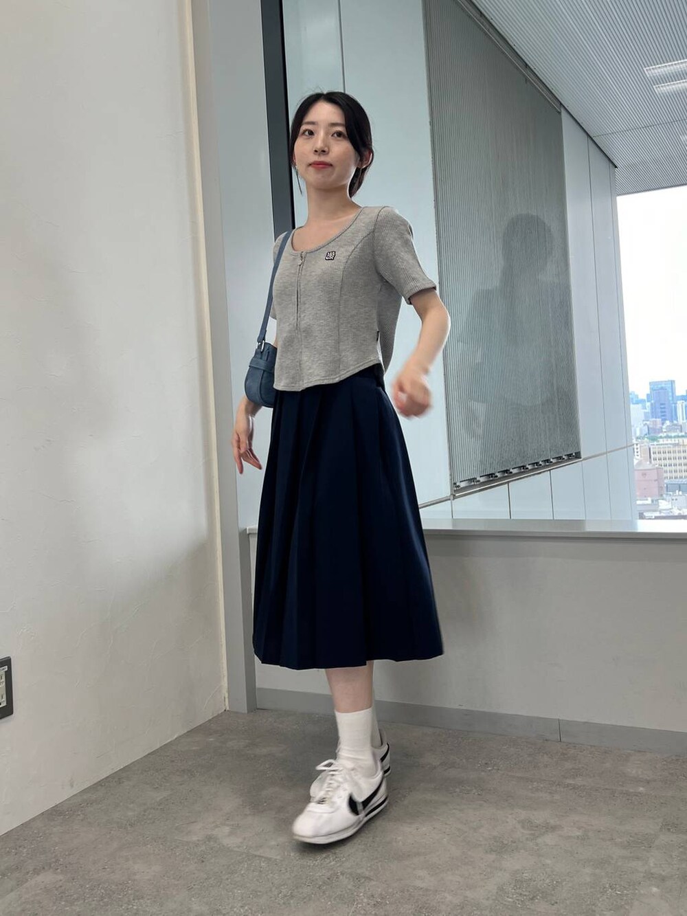 ブルー系のスカート、ブルー系のトートバッグ、グレー系のTシャツ/カットソーを着用したレディースの夏コーディネートの3枚目の写真