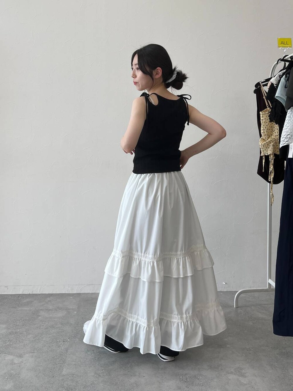 ホワイト系のスカート、ブラック系のキャミソールを着用したレディースの夏コーディネートの5枚目の写真