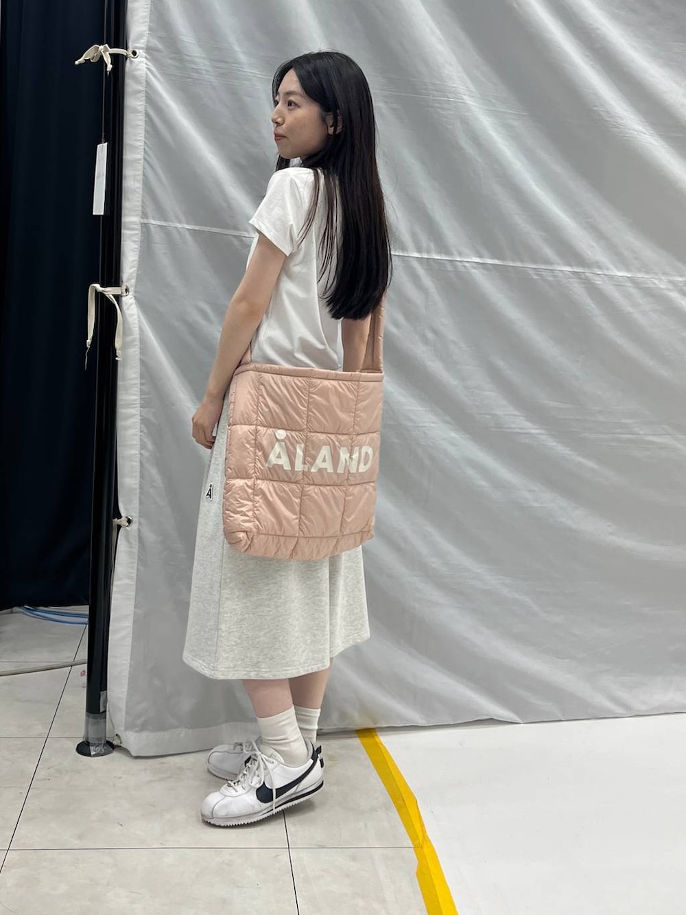 グレー系のスウェットパンツ、ピンク系のショルダーバッグ、ホワイト系のTシャツ/カットソーを着用したレディースの夏コーディネートの3枚目の写真