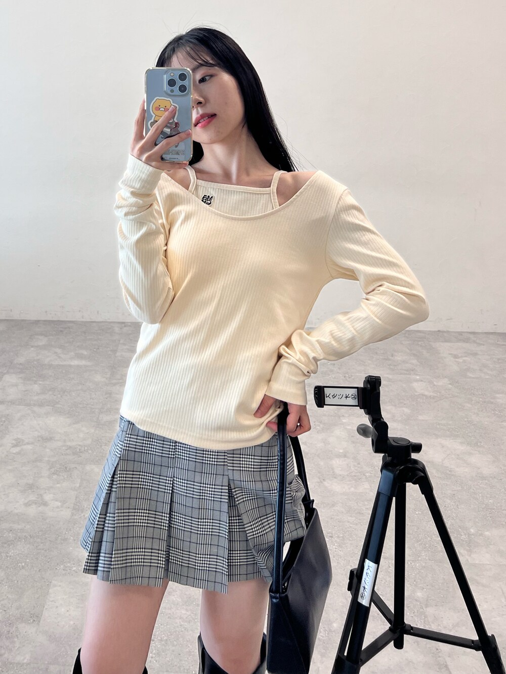 ブラック系のブーツ、ブラック系のショルダーバッグ、グレー系のスカートを着用したレディースの冬コーディネートの3枚目の写真