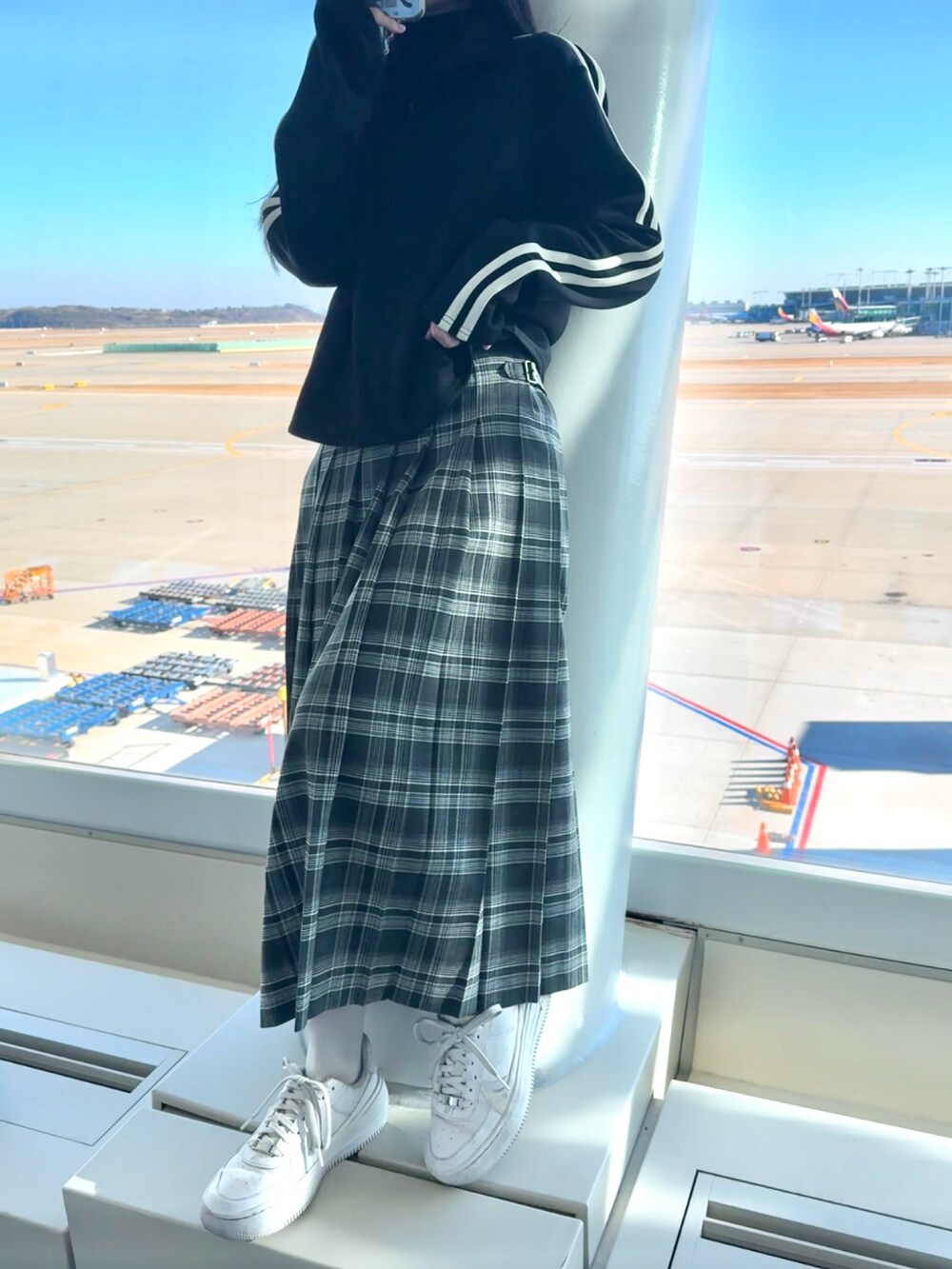 ホワイト系のスニーカー、グレー系のスカート、ブラック系のTシャツ/カットソーを着用したレディースの冬コーディネートの4枚目の写真