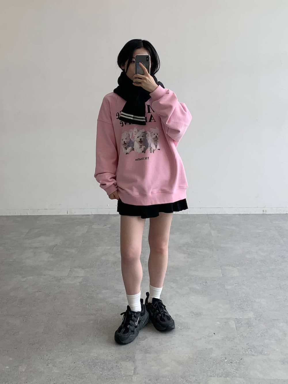 ブラック系のスカート、ピンク系のスウェット、ブラック系のマフラーを着用したレディースの秋コーディネートの3枚目の写真