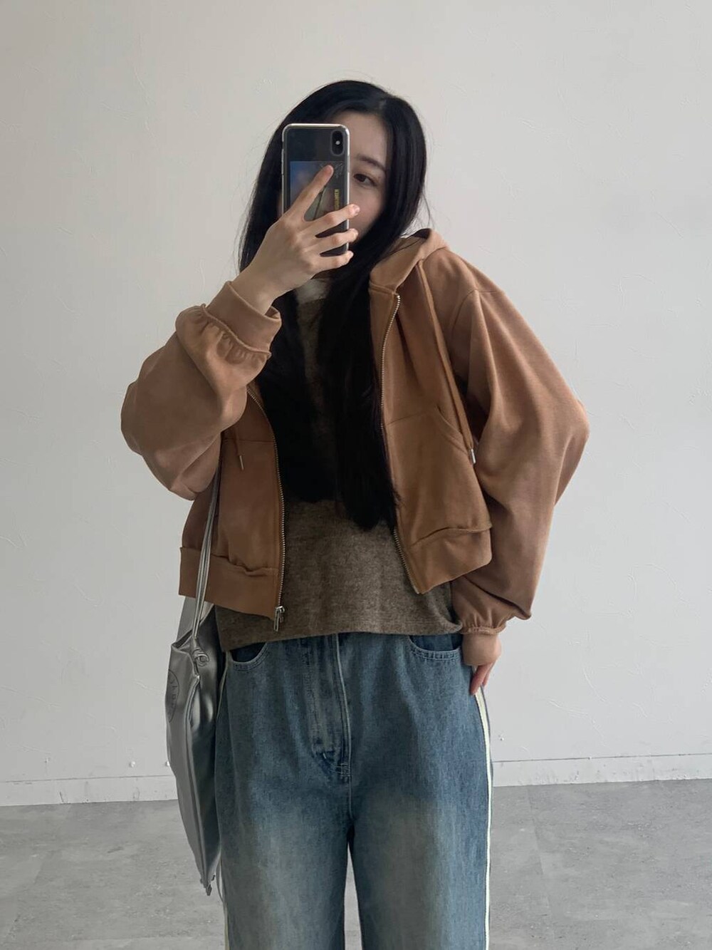 ブラウン系のパーカー、その他のデニムパンツ、グレー系のバックパック/リュックを着用したレディースの秋コーディネートの7枚目の写真