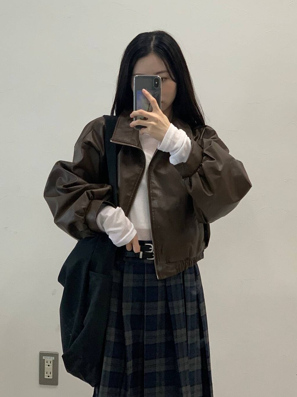 ブラック系のショルダーバッグ、ブラウン系のブルゾン、グレー系のスカートを着用したレディースの秋コーディネートの6枚目の写真