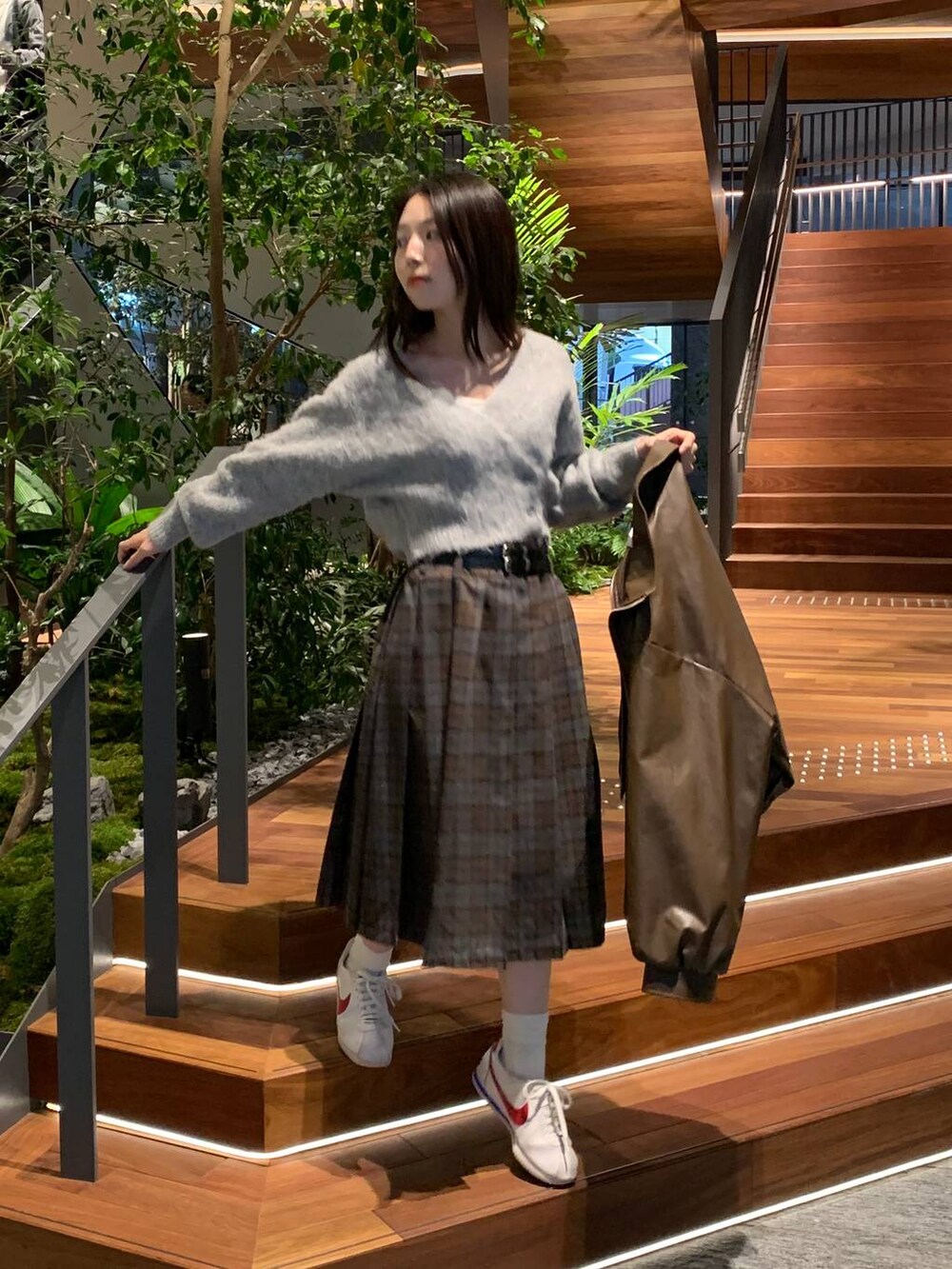 グレー系のカーディガン/ボレロ、ブラウン系のブルゾン、ブラウン系のスカートを着用したレディースの秋コーディネートの3枚目の写真