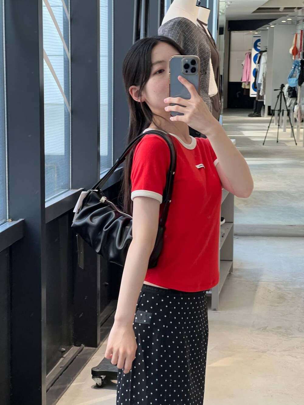 ブラック系のトートバッグ、ブラック系のスカート、レッド系のTシャツ/カットソーを着用したレディースの夏コーディネートの4枚目の写真