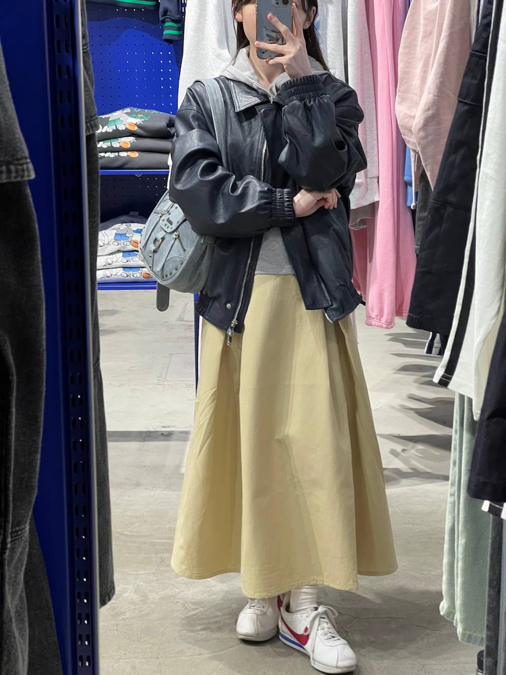 ベージュ系のスカート、ブルー系のブルゾン、グレー系のパーカーを着用したレディースの春コーディネートの4枚目の写真