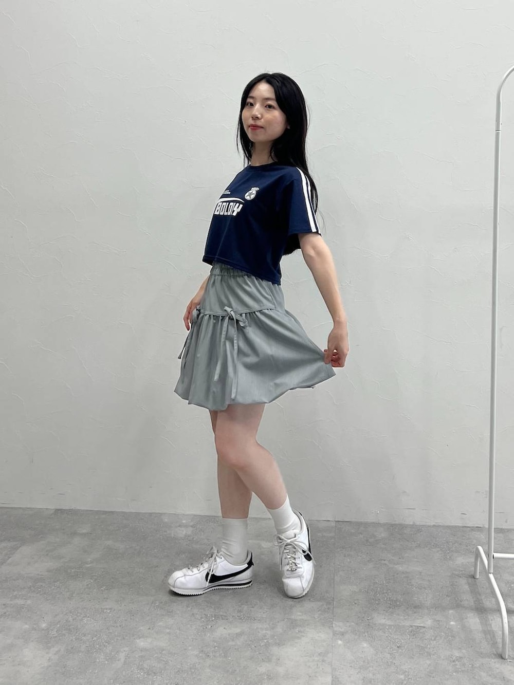 グレー系のスカート、ブルー系のTシャツ/カットソーを着用したレディースの夏コーディネートの2枚目の写真