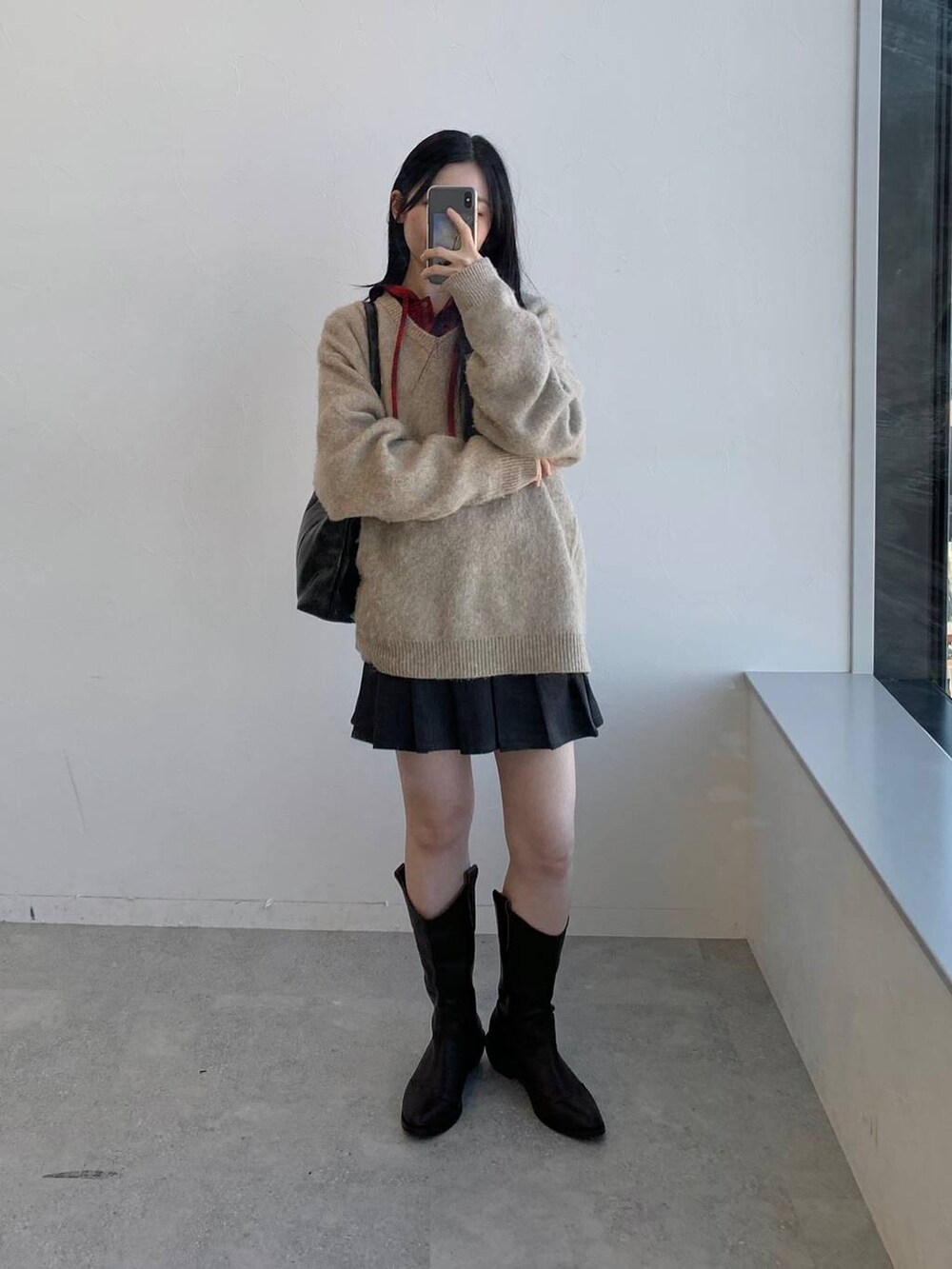 レッド系のシャツ/ブラウス、グレー系のスカート、ブラック系のハンドバッグを着用したレディースの冬コーディネートの4枚目の写真