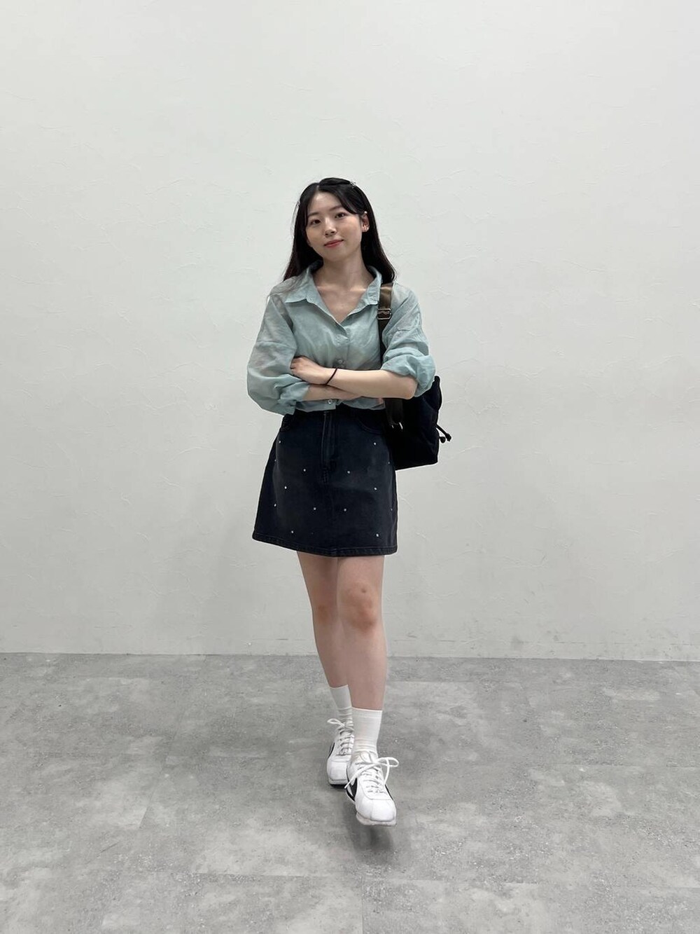 ブラック系のデニムスカート、ブルー系のシャツ/ブラウスを着用したレディースの春コーディネートの5枚目の写真