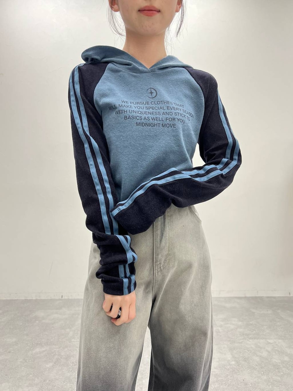 ブラック系のデニムパンツ、ホワイト系のスニーカー、ブルー系のTシャツ/カットソーを着用したレディースの冬コーディネートの5枚目の写真